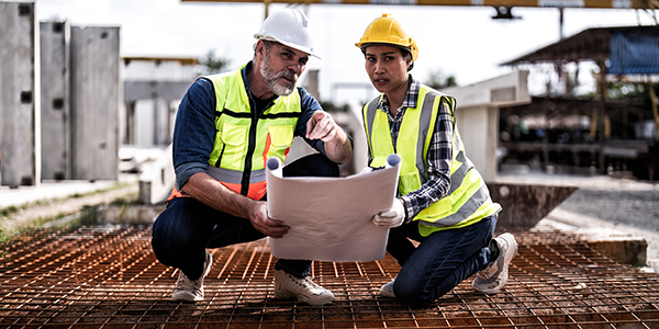 At construction site senior engineer and supervisor check steel